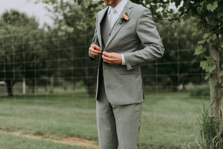 a man in a suit stands by the fence