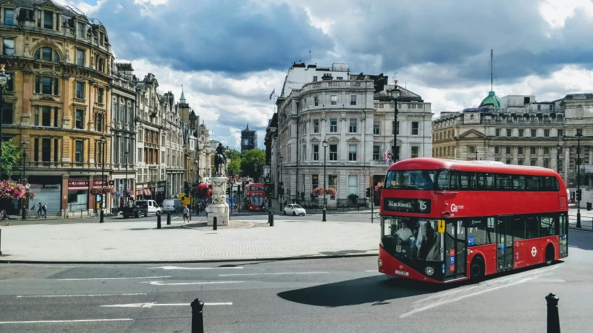 red double decker bus moving down a busy city street