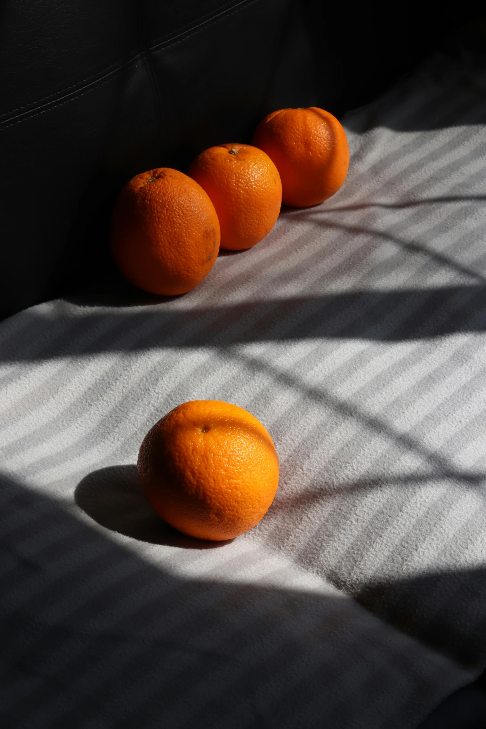 a set of oranges laying on a bed