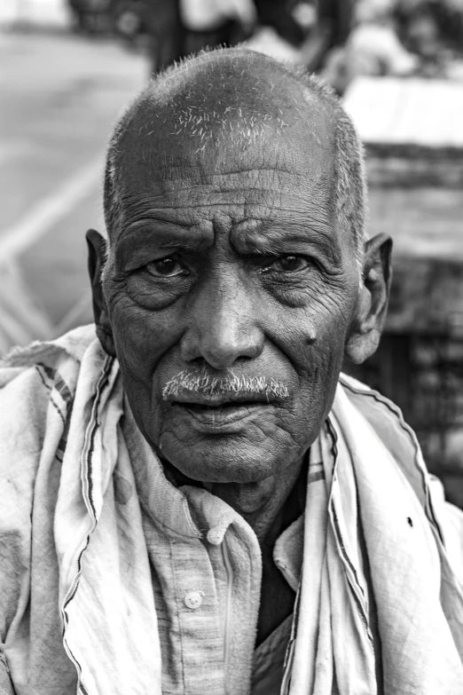 a man with a white hair and big eyes is sitting