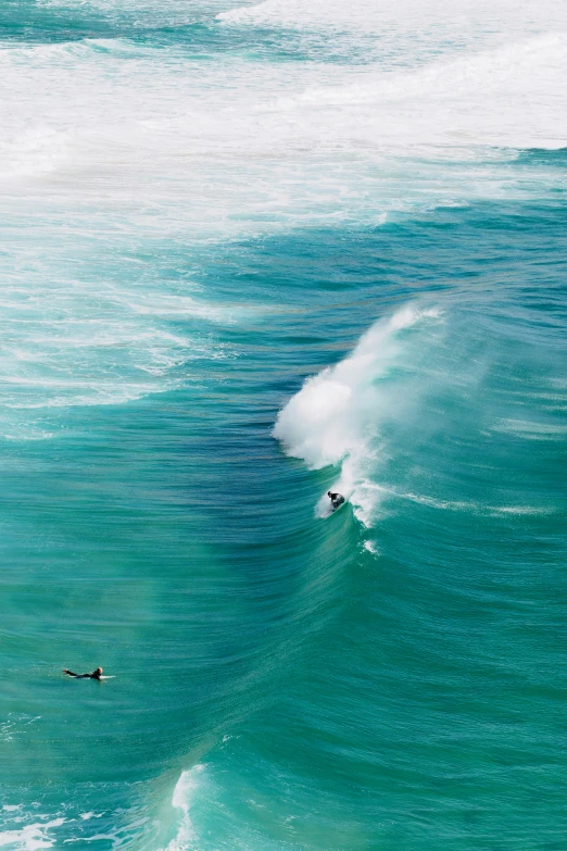 a surfer is riding a wave and one person is on a board