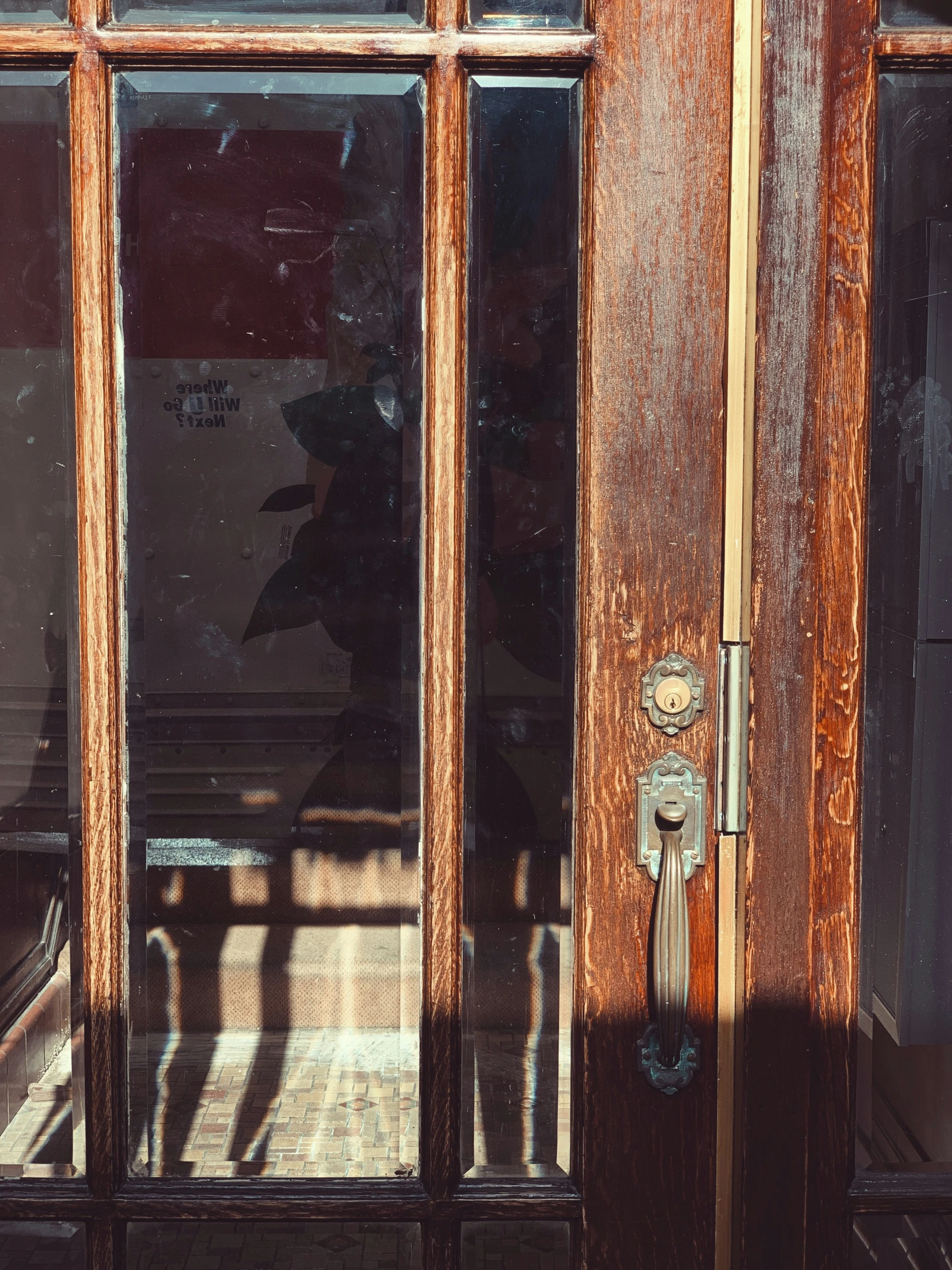 a wooden door with an ornate handle and glass