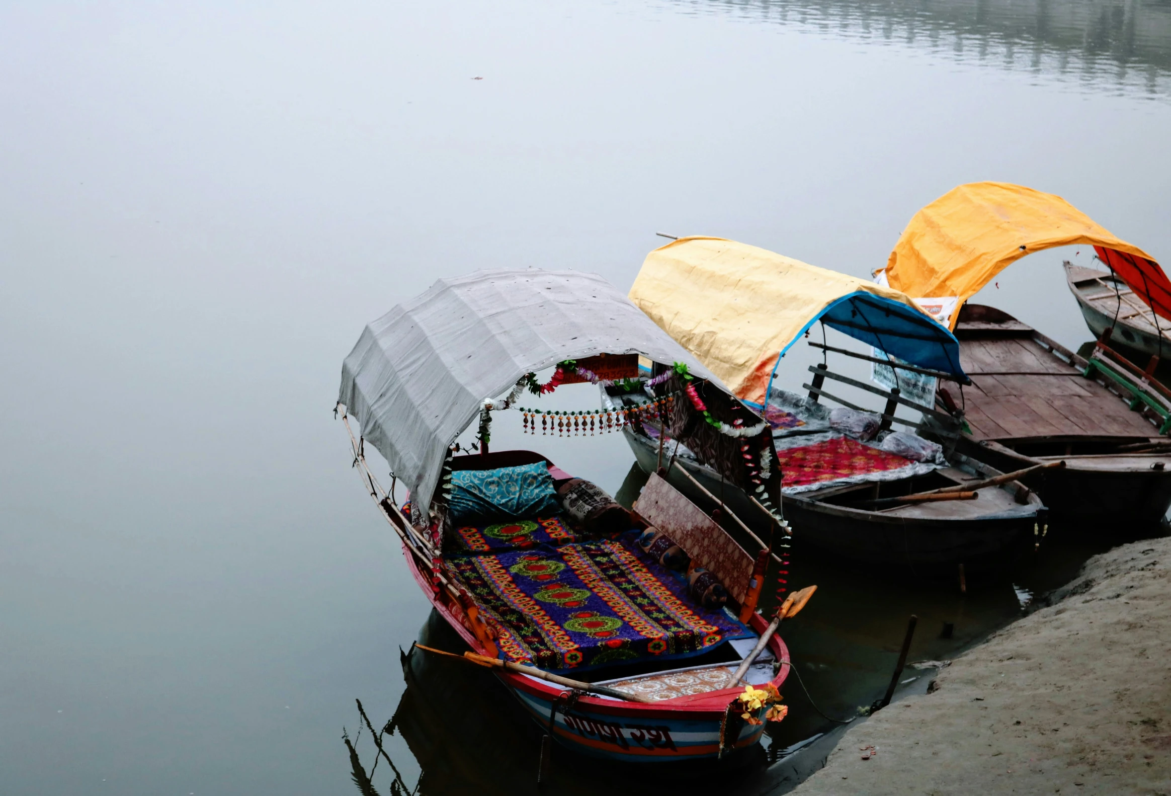 boats tied up at the shore of a body of water