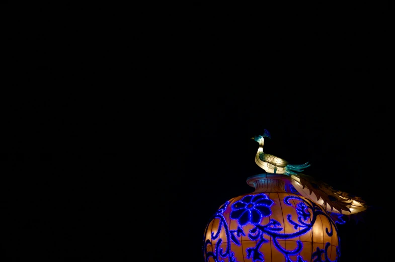 there is an illuminated egg on top of the building
