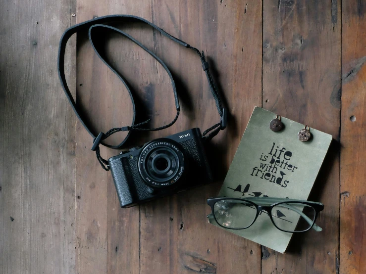 an old camera is on top of a card and a leather case