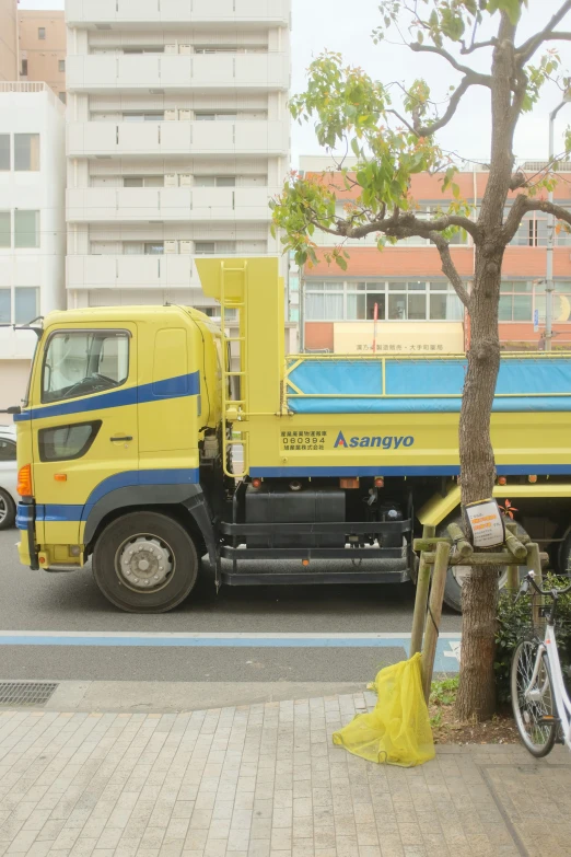 a yellow truck with blue accents parked on the side of the road