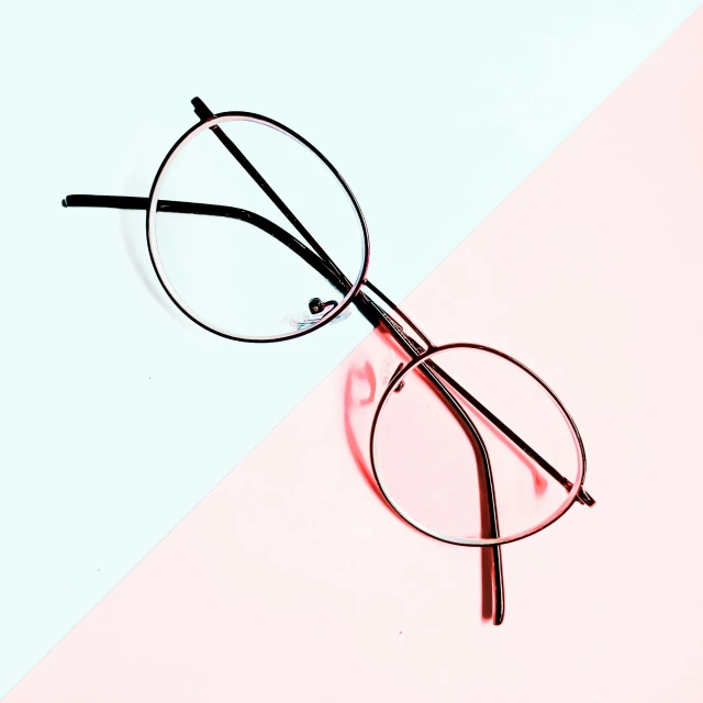 a pair of glasses sitting on top of a pink and blue table