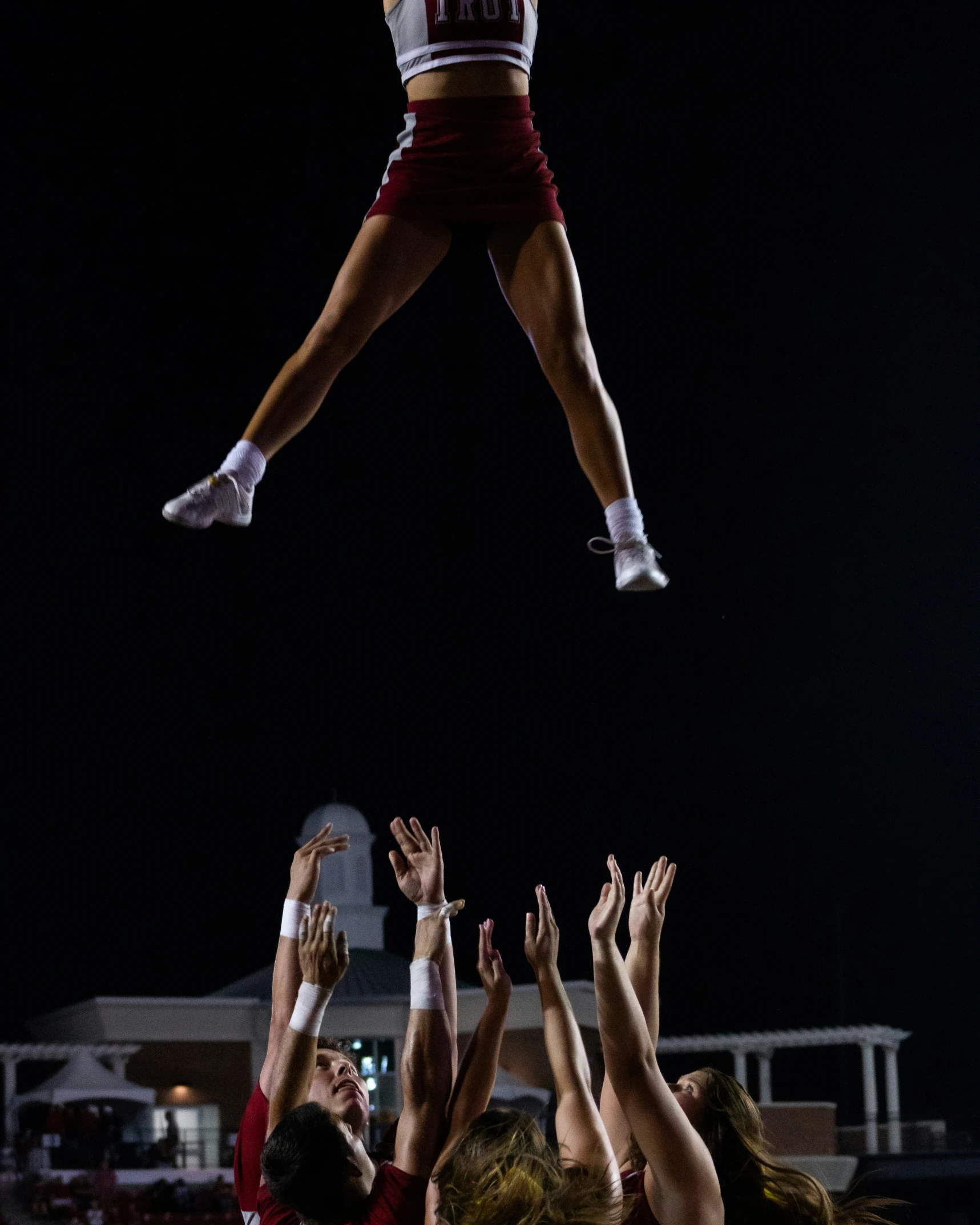 a cheerleader in the air with her arms in the air