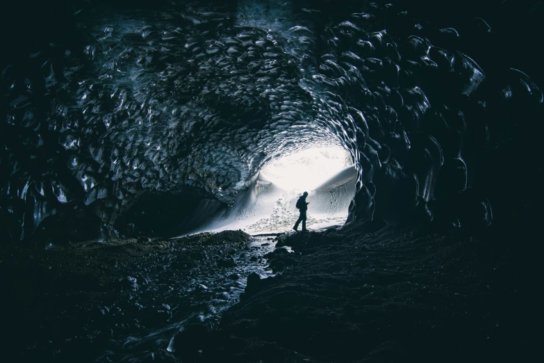 a person stands in the middle of a cave