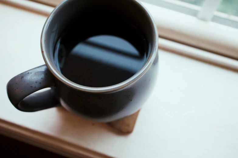 an up close s of the inside of a coffee cup on a window sill