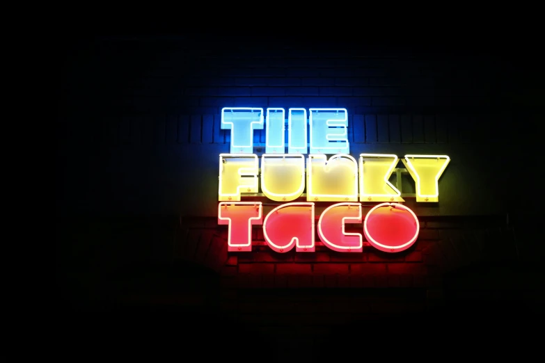 a very pretty colorful neon sign with the word y taco on it