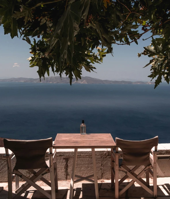 two chairs on the deck of a home near the ocean