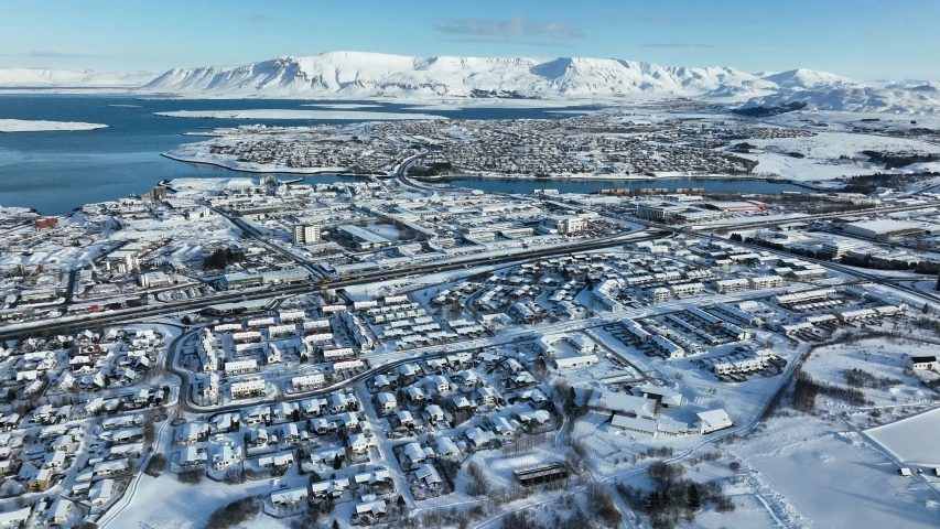 an aerial view of snow covered suburbs in the background