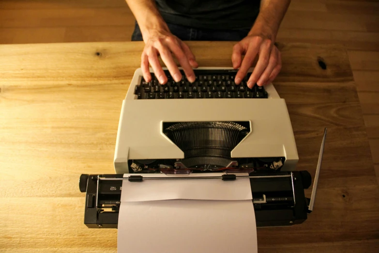 a hand is typing on a typewriter to write soing