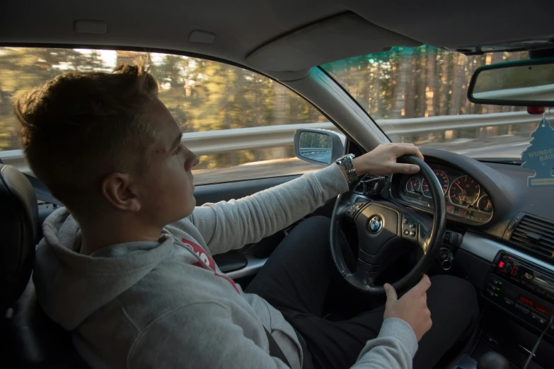 a man driving in a car on the highway