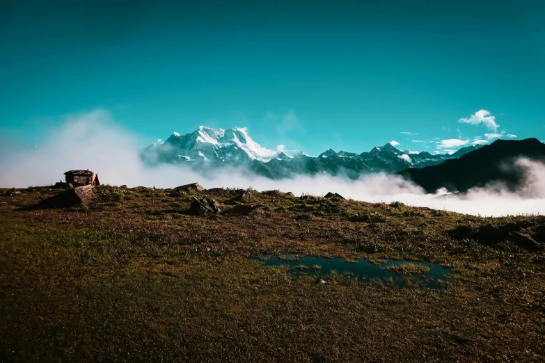 the sky and clouds are rolling over the rocky slopes