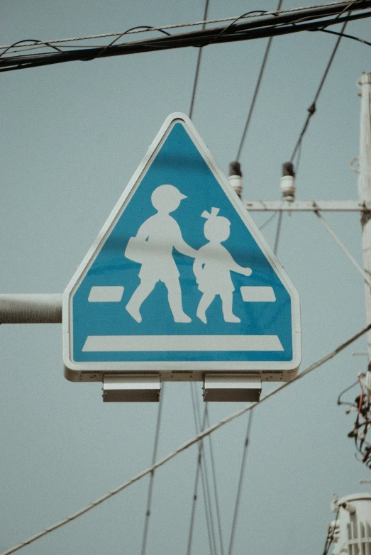 there is a child crossing sign under wires