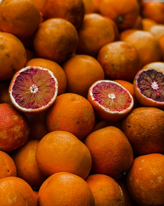 a pile of oranges, that have cut in half