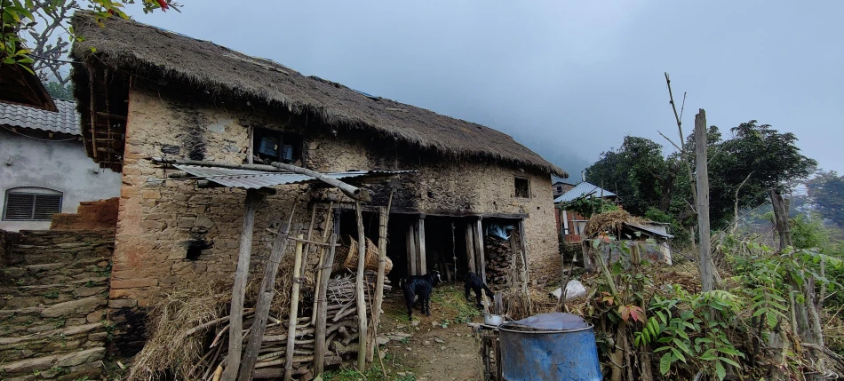 a small stone building on a dirt road