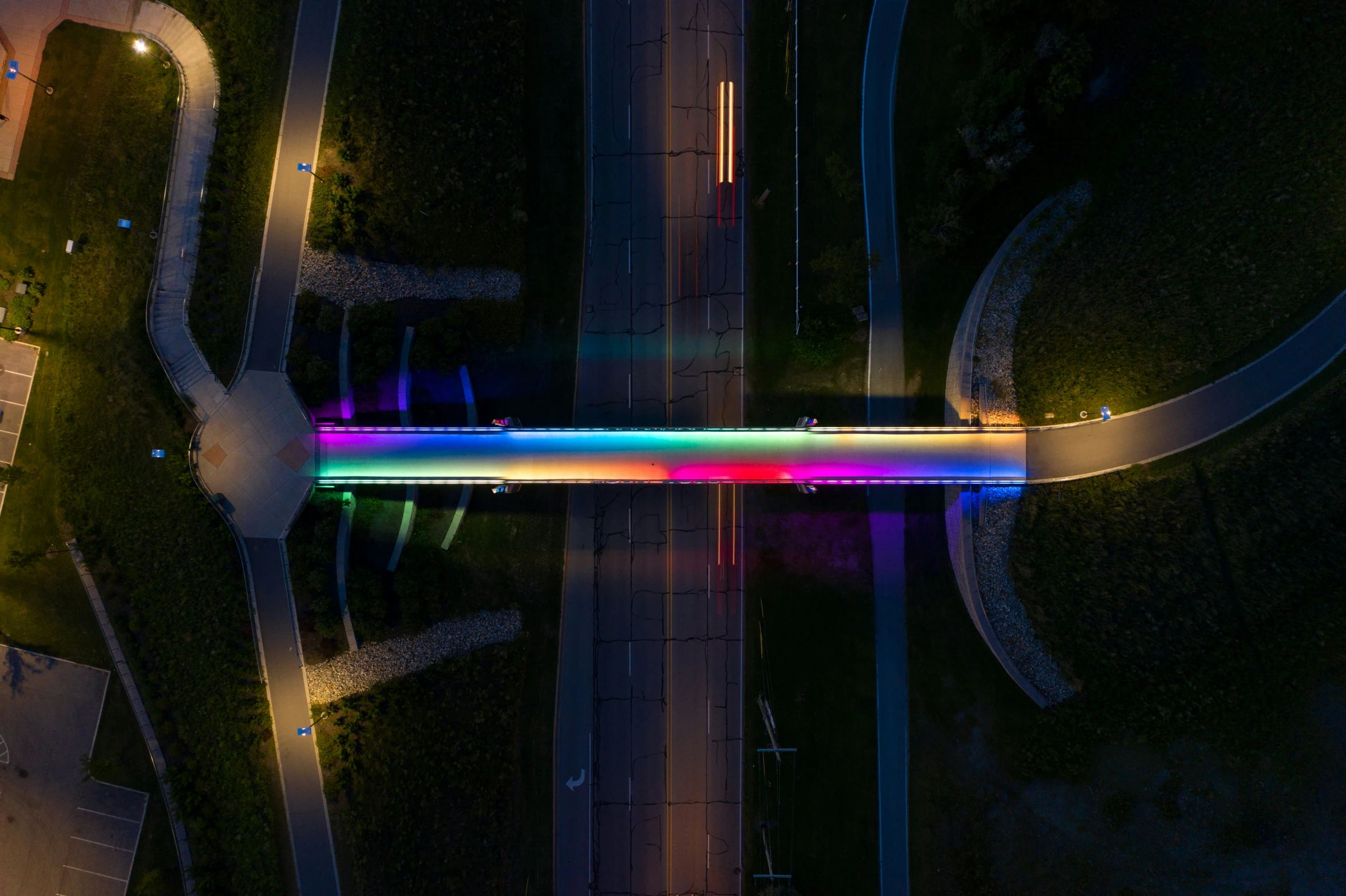 an aerial s of a long pedestrian bridge at night