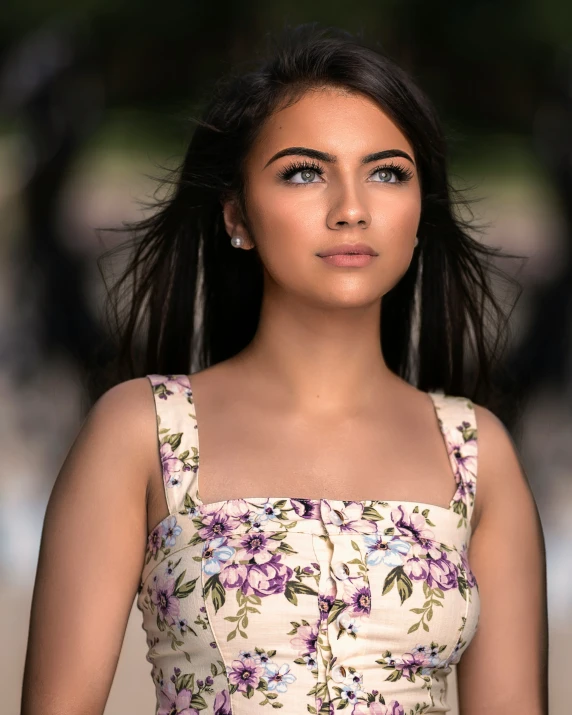 a woman with brown eyes wearing a floral dress