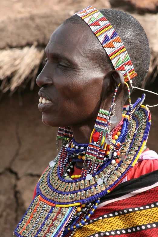 a person with a head piece wearing jewelry and a smile