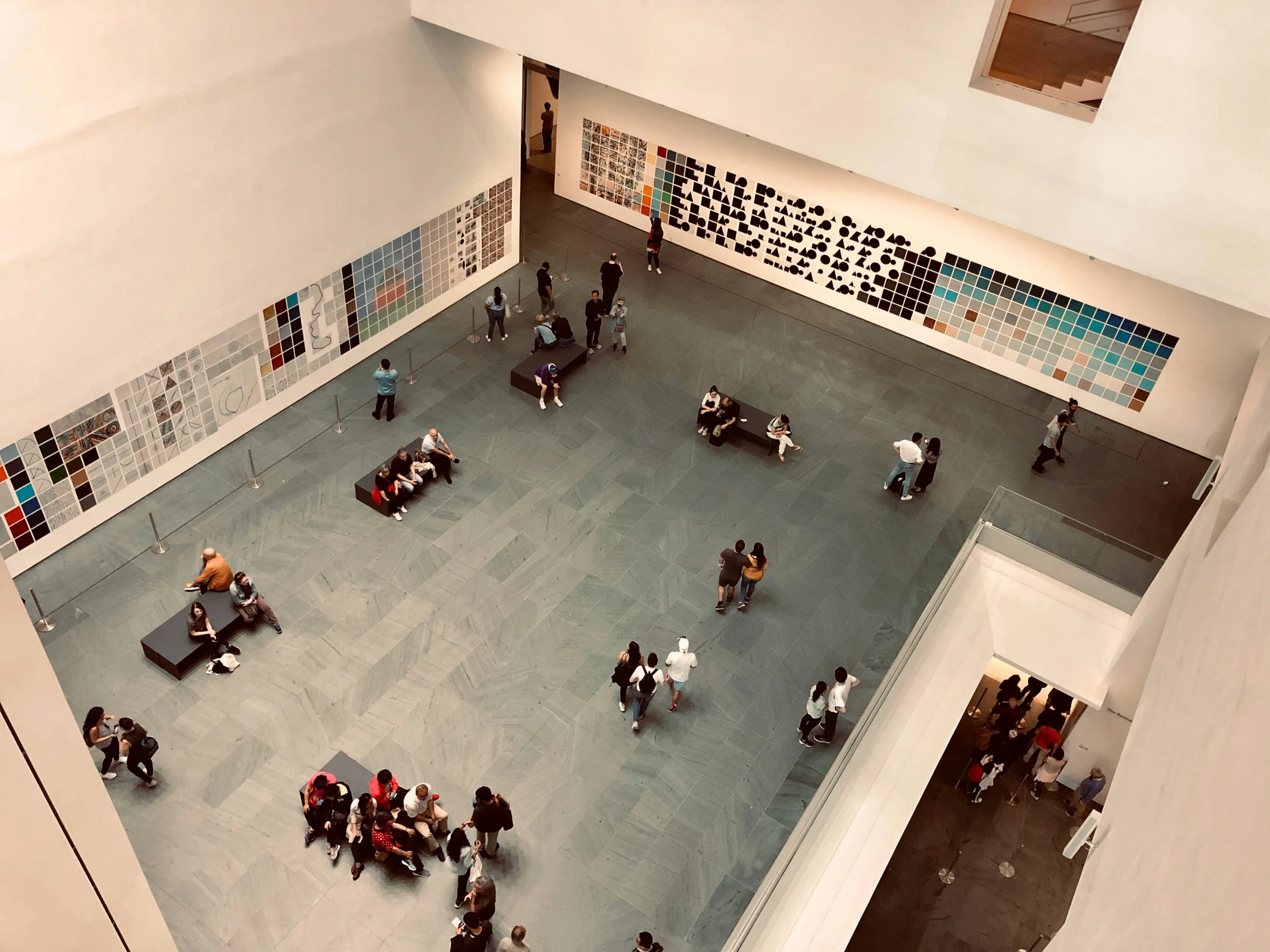 people standing in an area with posters on the wall