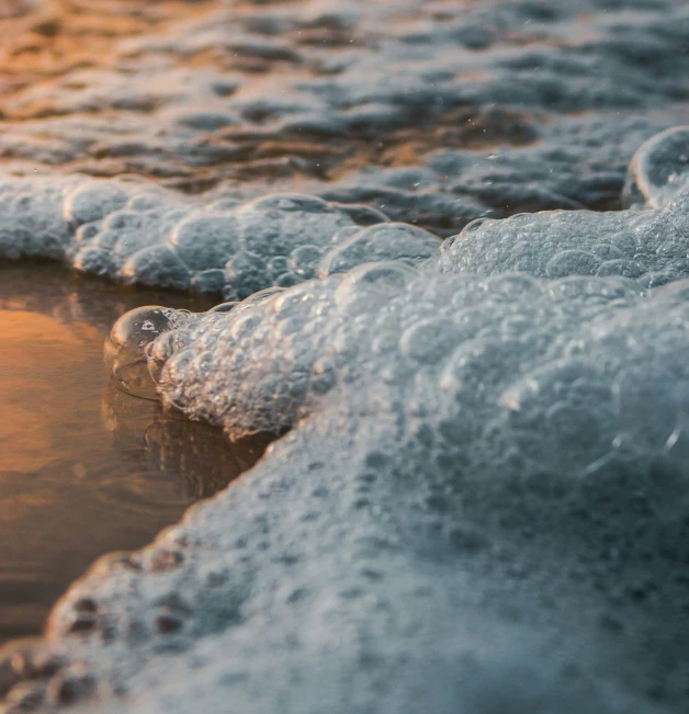 a closeup view of the waves on a sandy beach