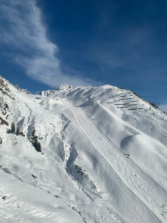 a ski slope is covered in snow in front of mountains