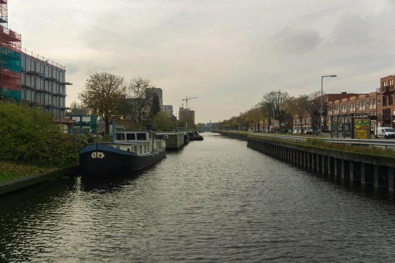 boats sit in a canal on a cloudy day