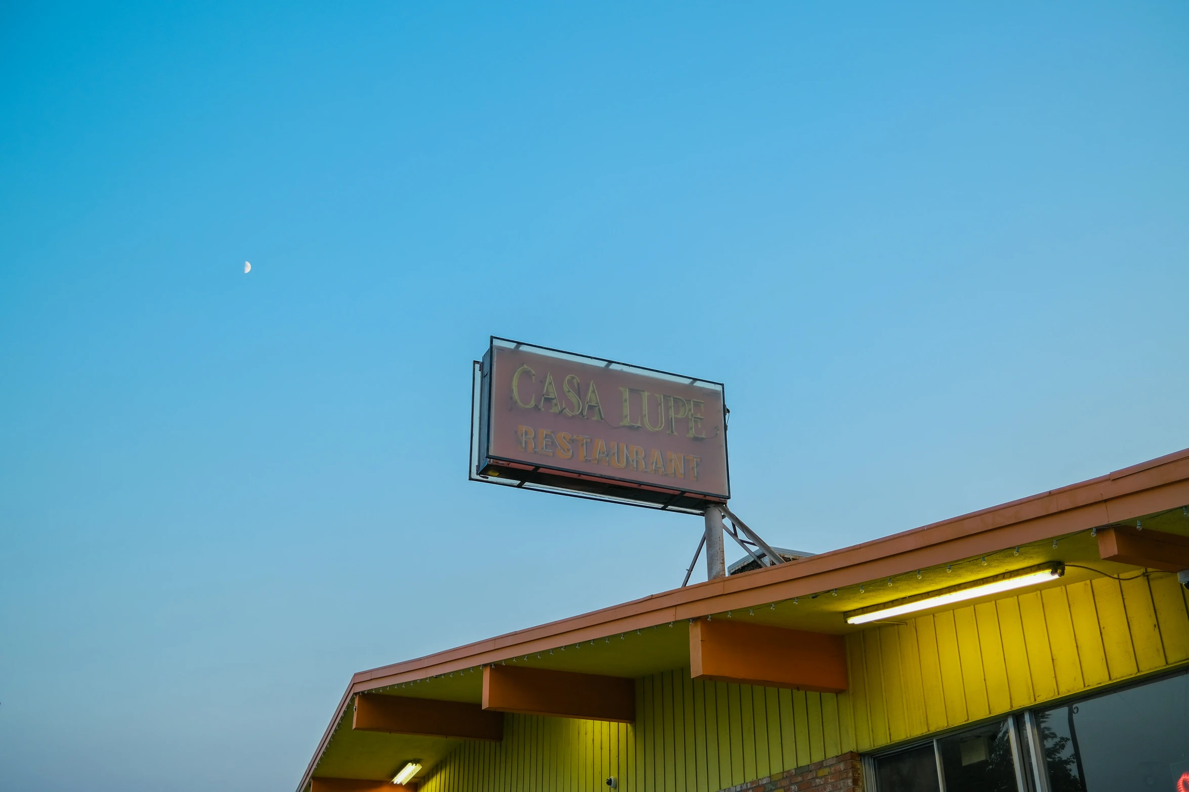 a sign is posted at the top of a yellow building