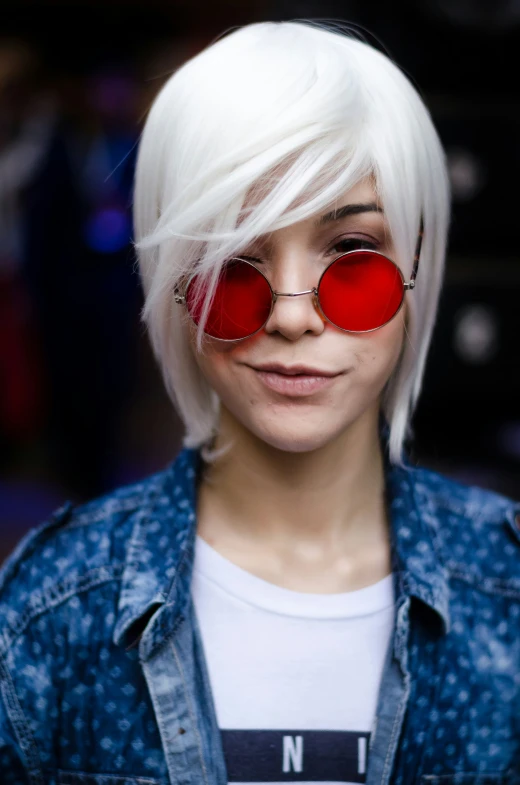 a young woman with red glasses looks into the camera