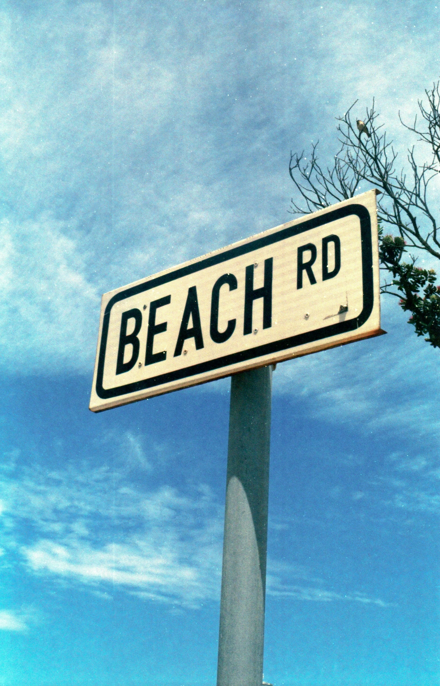 a white street sign that reads beach rd on it