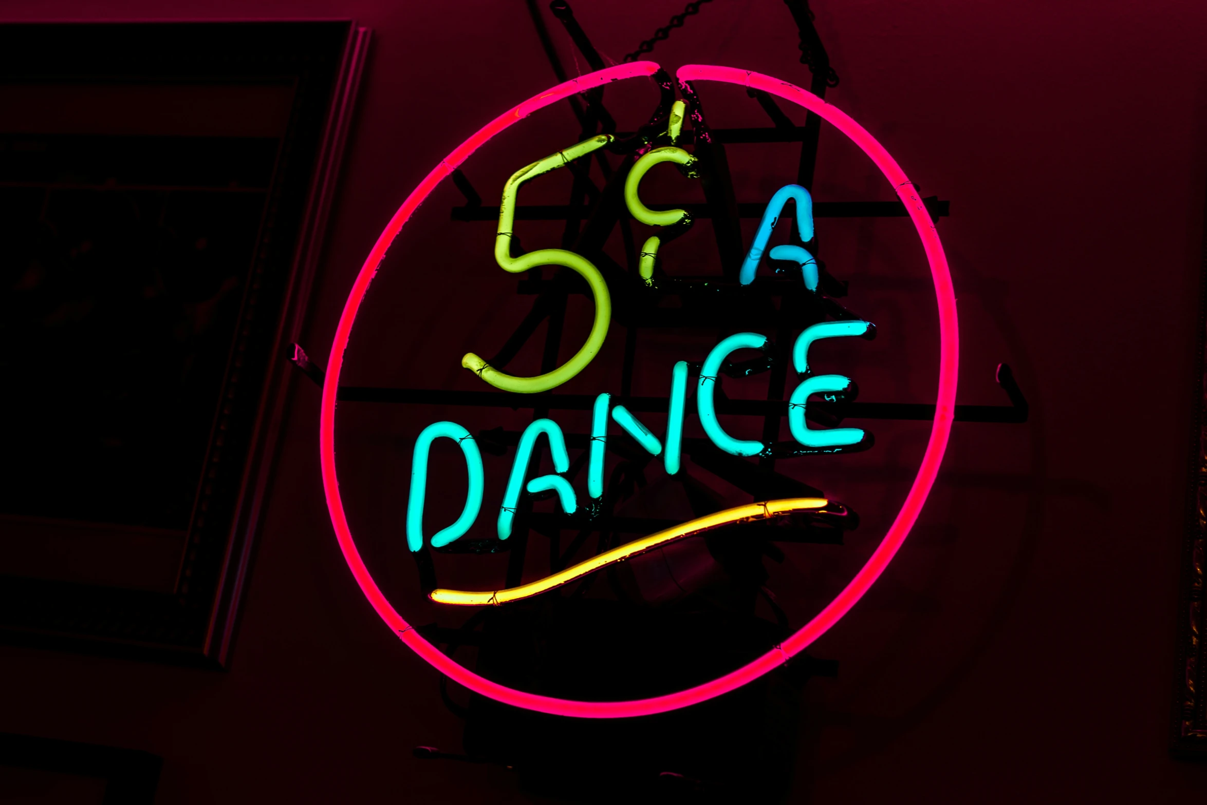 a neon sign sitting up against a wall