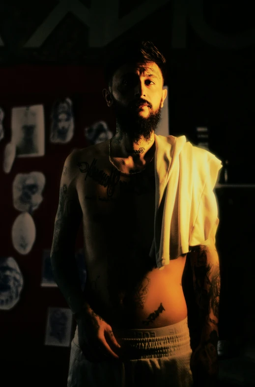 a bearded man with tattoos on his chest wearing boxer shorts
