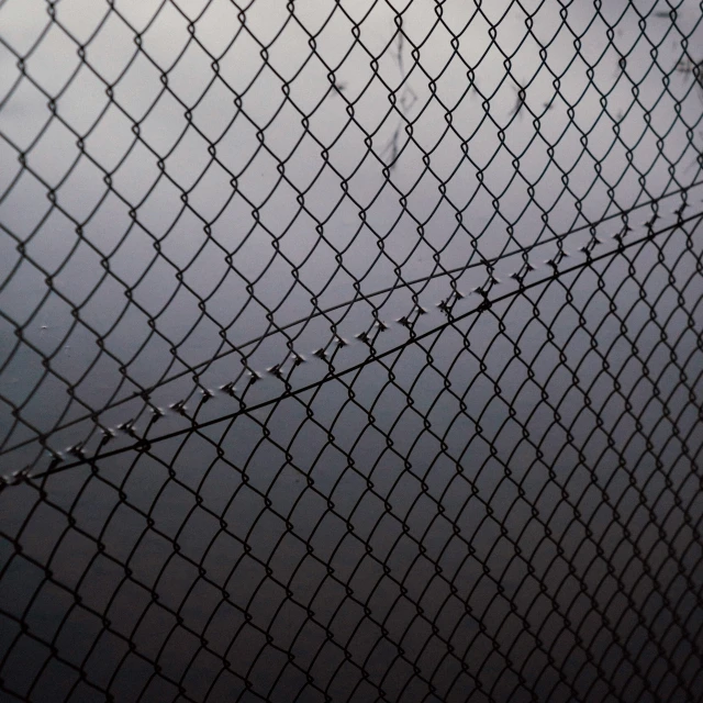 a very tall chain link fence by the sky