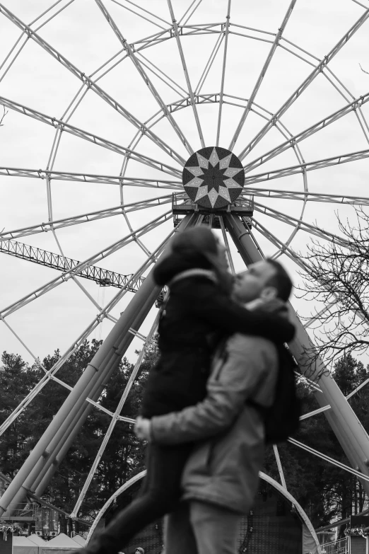 a man and woman walk by the ferris wheel