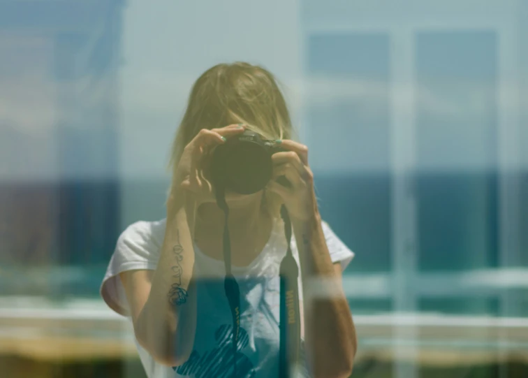 the woman is taking a po through a glass window