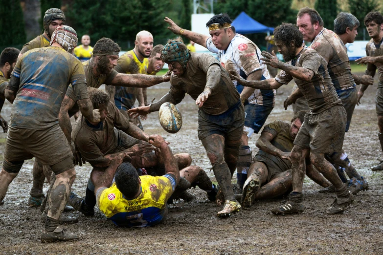 a group of people playing a game of frisbee on the muddy ground