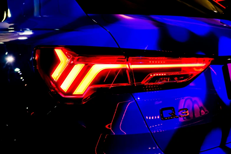 the tail lights of a car in blue and red