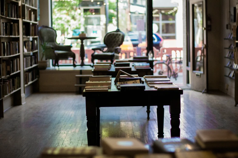 a room filled with tables, books and a window