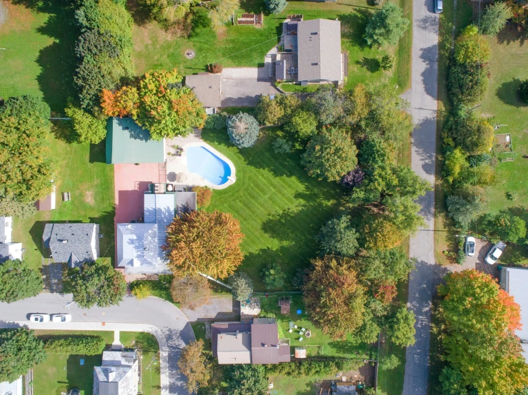 an aerial view of houses and lawns with water feature