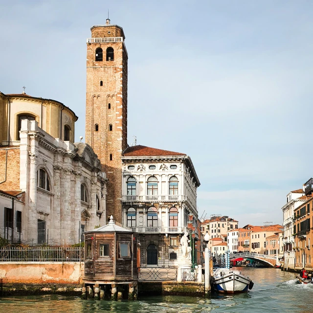 the river runs alongside several buildings and boats