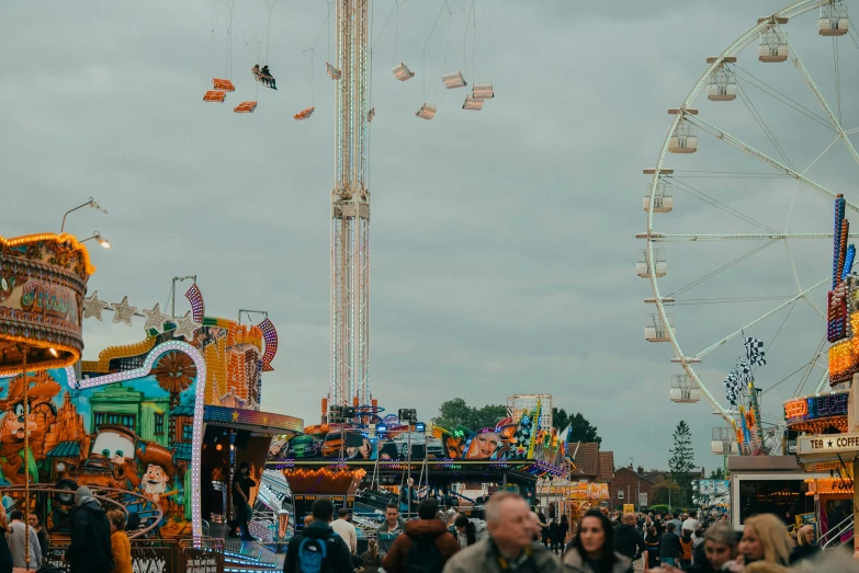 several carnival rides and large ferris wheel with s