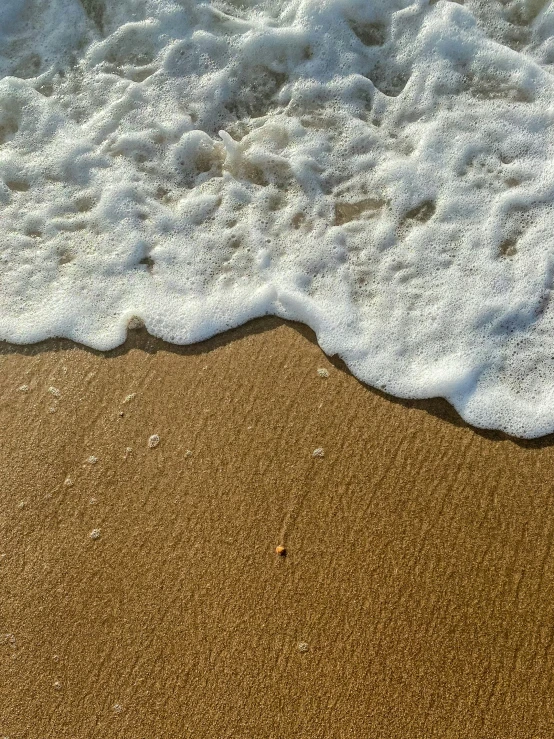 a sandy beach with waves coming in and out