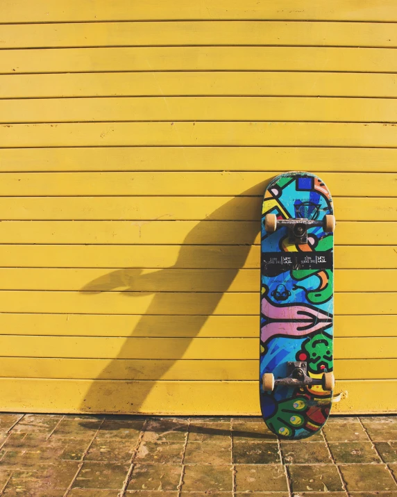 a skateboard leaning against the wall with an artistic image