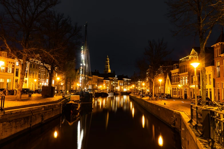 boats floating in the river with lights and buildings on either side