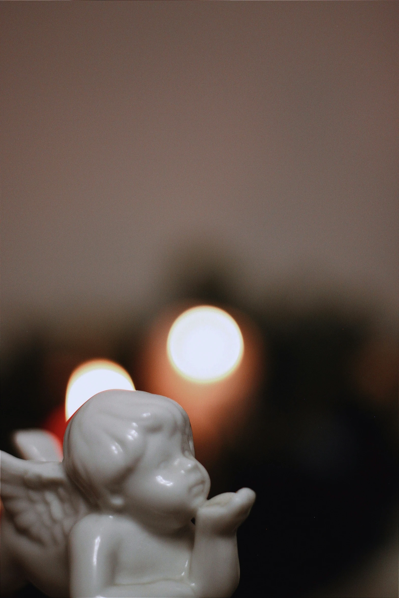 an angel figurine sits in the foreground with some candles lit