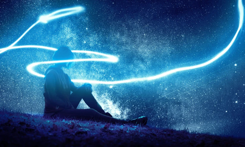 a person sitting on the ground and a light painting
