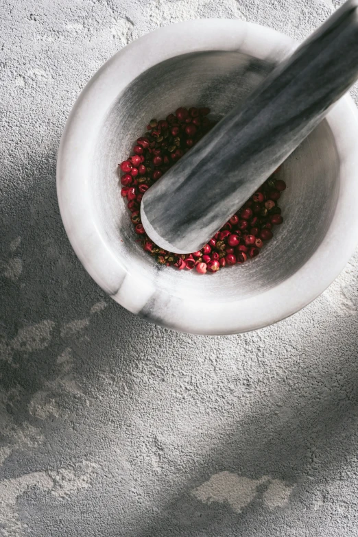 a white mortar and pestle are in a bowl